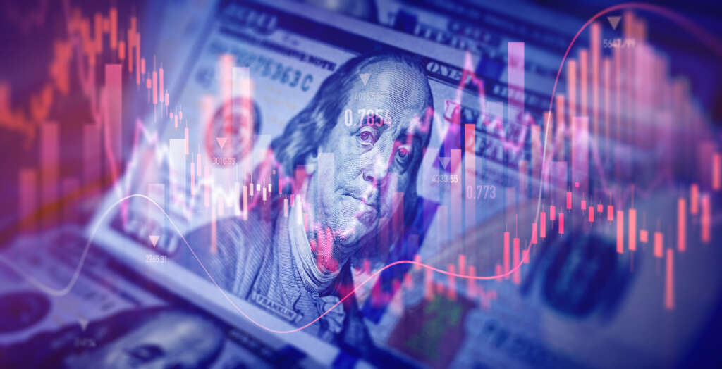 Digital stock market charts and financial data overlaid on a U.S. hundred-dollar bill, representing economic volatility and financial distress.