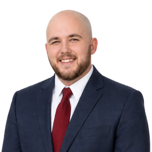 Professional headshot of attorney Carson R. Hicks wearing a navy suit, white dress shirt, and red tie, smiling against a light background.