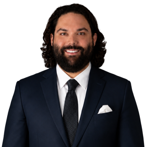 Professional headshot of attorney Henry Yaniz wearing a dark navy suit, white shirt, and dark tie against a white background.